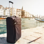 Small Suitcase on Travel Urban Background, Venice, Italy. Horizontal. Toning. Travel Vacation Concept.