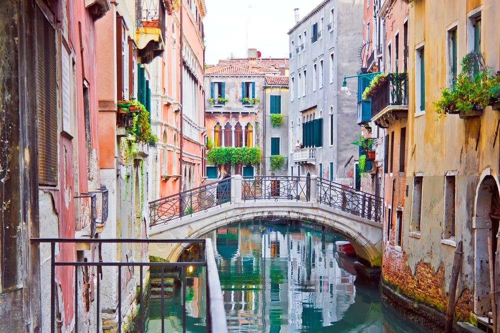 A canal and old white bridge in Venice, Italy