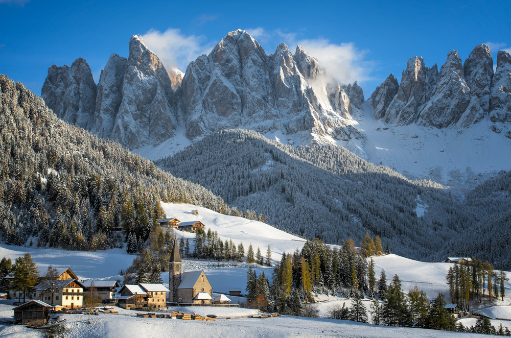 The small village of St. Magdalena or Santa Maddalena with its church covered in snow and with the Odle or Geisler Dolomites mountains behind it in the Val di Funes Valley (Villnösstal) in South Tyrol in Italy in winter.