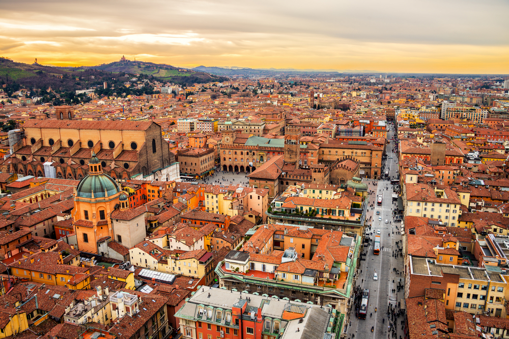 Aerial view of Bologna, Italy at sunset. Colorful sky over the historical city center with car traffic and old buildings