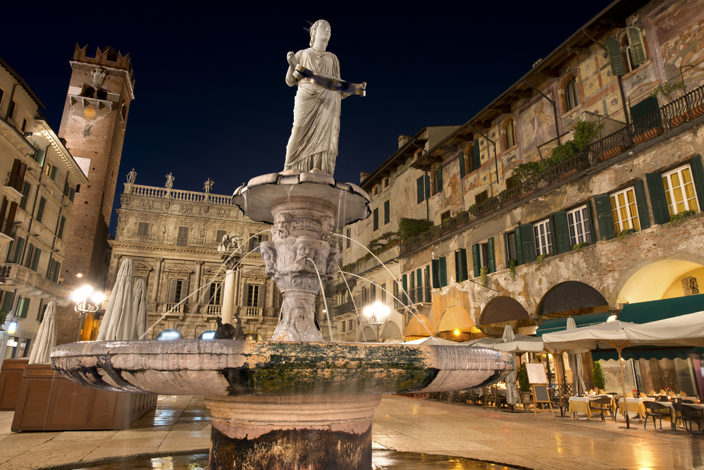 Piazza delle Erbe at night, in the foreground the statue of Madonna Verona - Italy