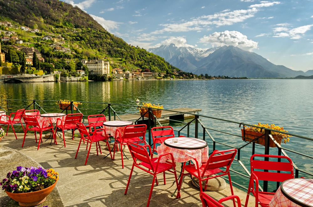 Milan to Lake Como in an hour to sit lakeside at these red tables and soak up the gorgeous views.