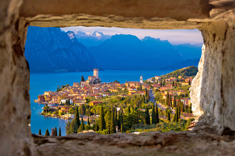 Malcesine and Lago di Garda aerial view through stone window, Veneto region of Italy