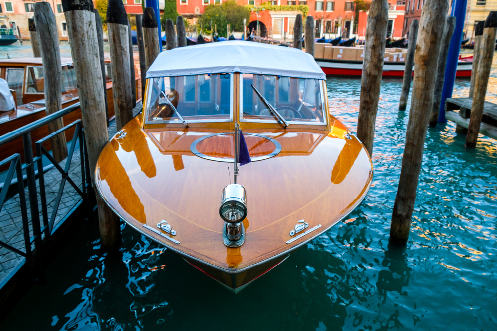 Wooden retro boat taxi parked on the canal in Venice