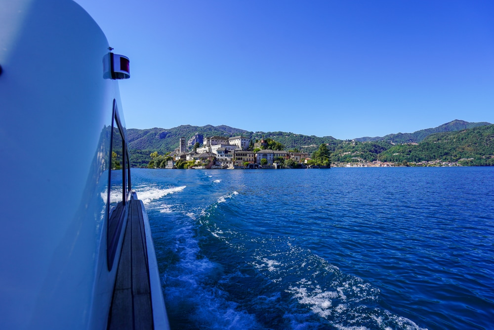 side of a boat with isola san giulio in the distance on Lake Orta in Piedmont Italy