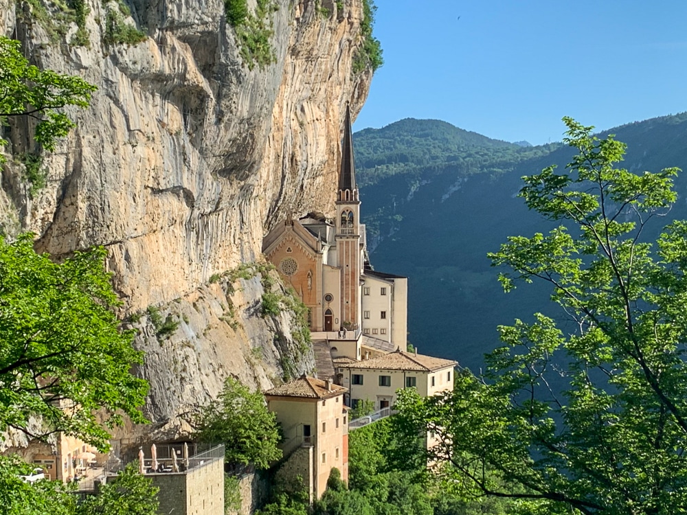 Madonna della Corona church sitting on a rocky ledge on the side of a mountain in the region of Veneto in Italy