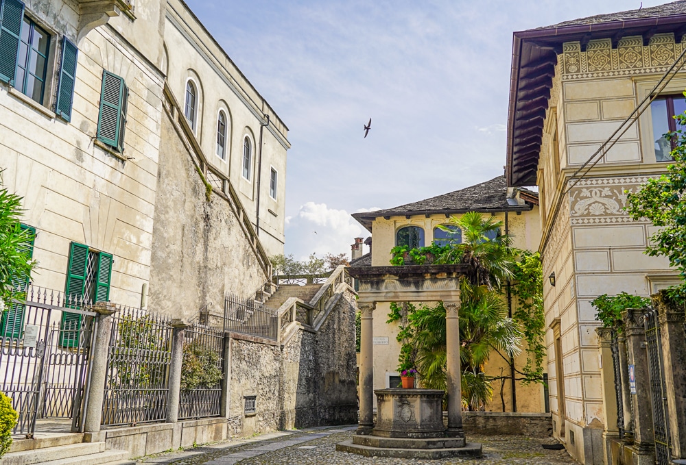 stone buildings with a well and walkway called the way of silence on Isola San Giulio at Lake Orta in Italy