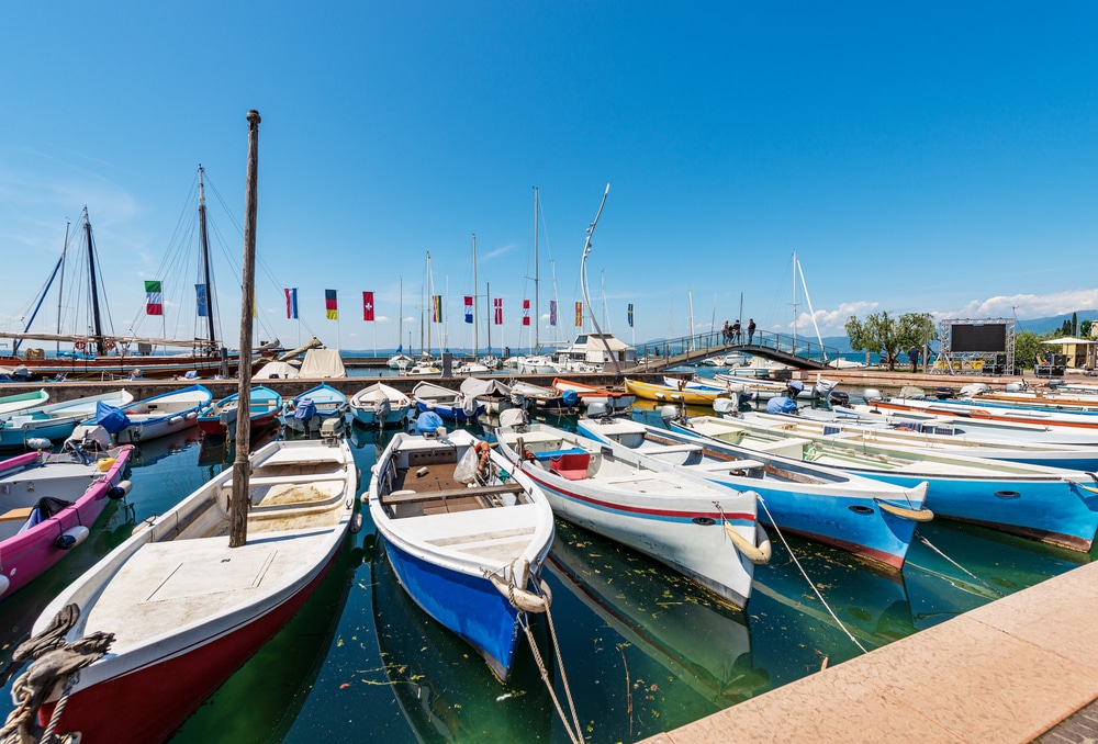Many fishing and recreational boats moored in the small port of Bardolino village. Tourist resort on the coast of Lake Garda (Lago di Garda). Verona province, Veneto, Italy, 