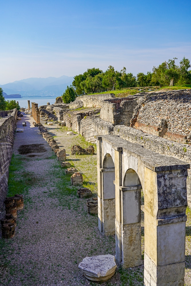 Roman ruins of Grottoes of Catallus in Sirmione Lake Garda. Lake views in the distance