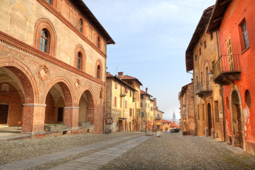 Paved street among old historic houses in town of Saluzzo, northern Italy.