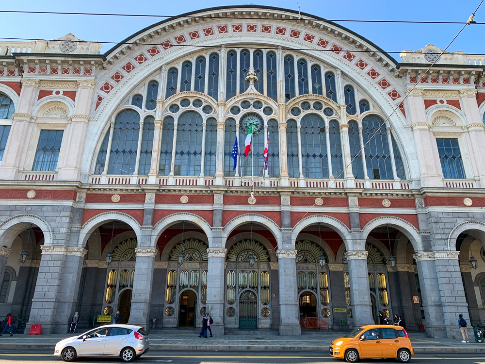 front of Turin Porta Nuova Train Station with 2 small cars driving by