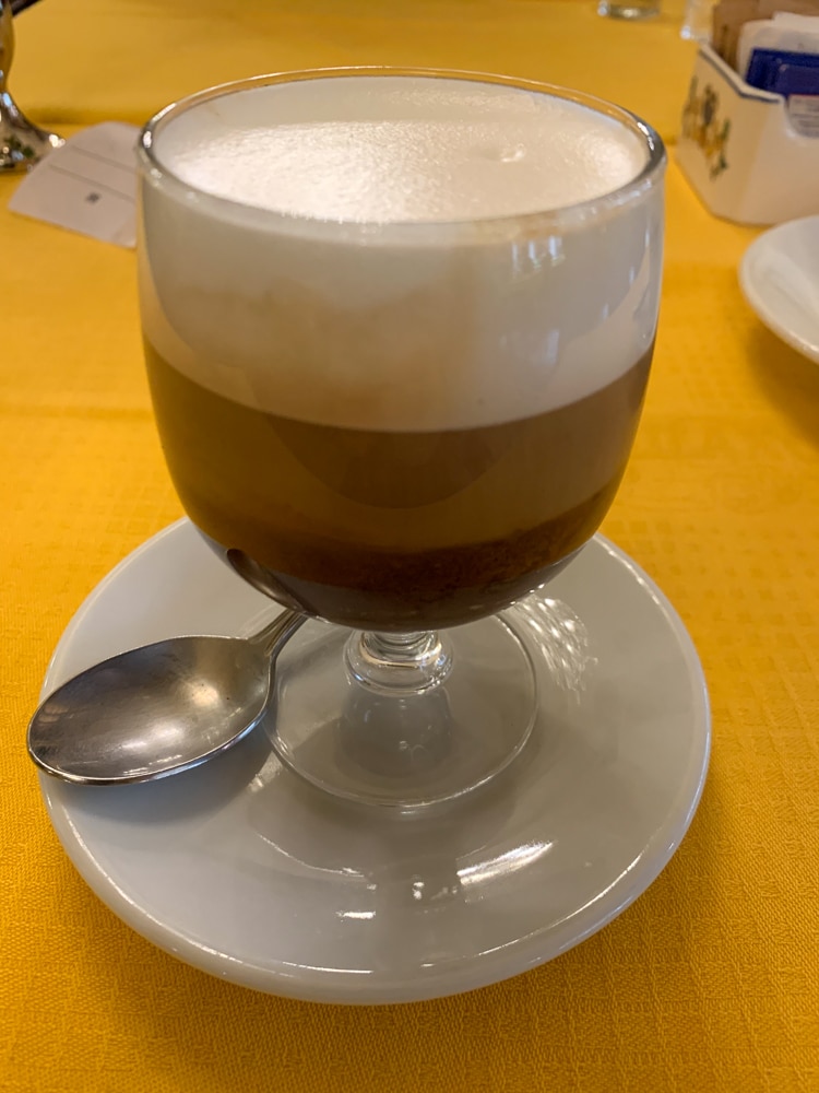 close up of a bicerin, the iconic drink of Turin Italy with 3 layers, espresso, chocolate, and cream