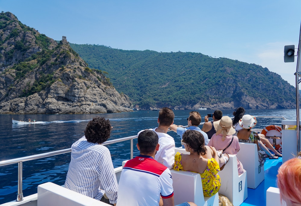view from on a boat of the Liguria and the Mediterranean Sea. Backs of people on the boat in the foreground