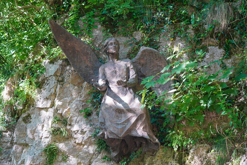 Statue of an angel attached to a rocky cliff Veneto