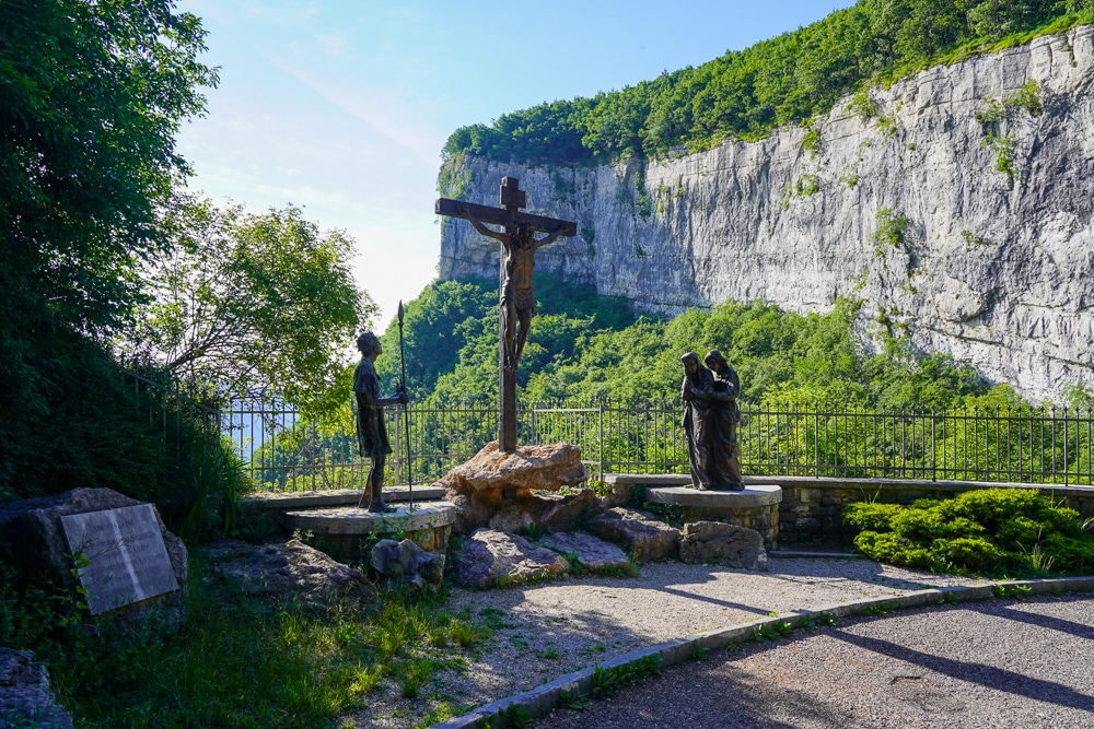 Way of the cross, via Crucis, with religious statues and a mountain cliff in the background