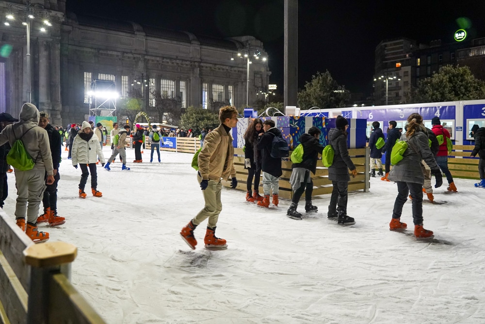 Ice skating rink with people outside the Milan central train station