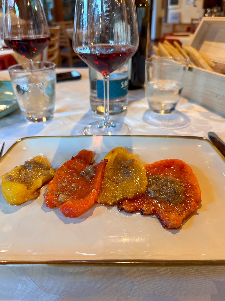 Bagna Cauda on a dish with a glass of wine at a restaurant in Italy