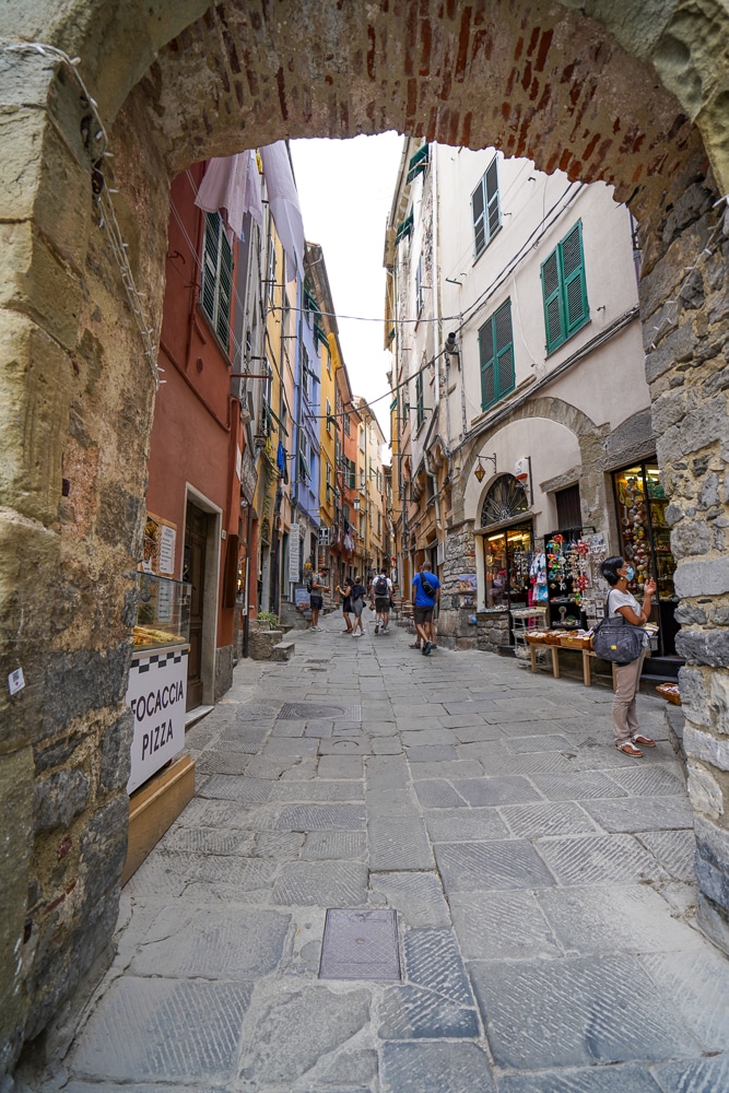 Stone archway into a medieval street with colorful houses in Portovenere Italy