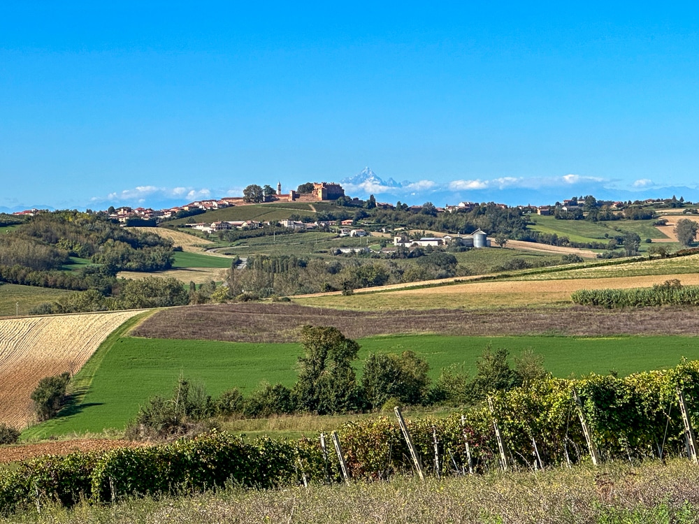 hills of monferrato with a village on a hill and the alps in the distance Italy
