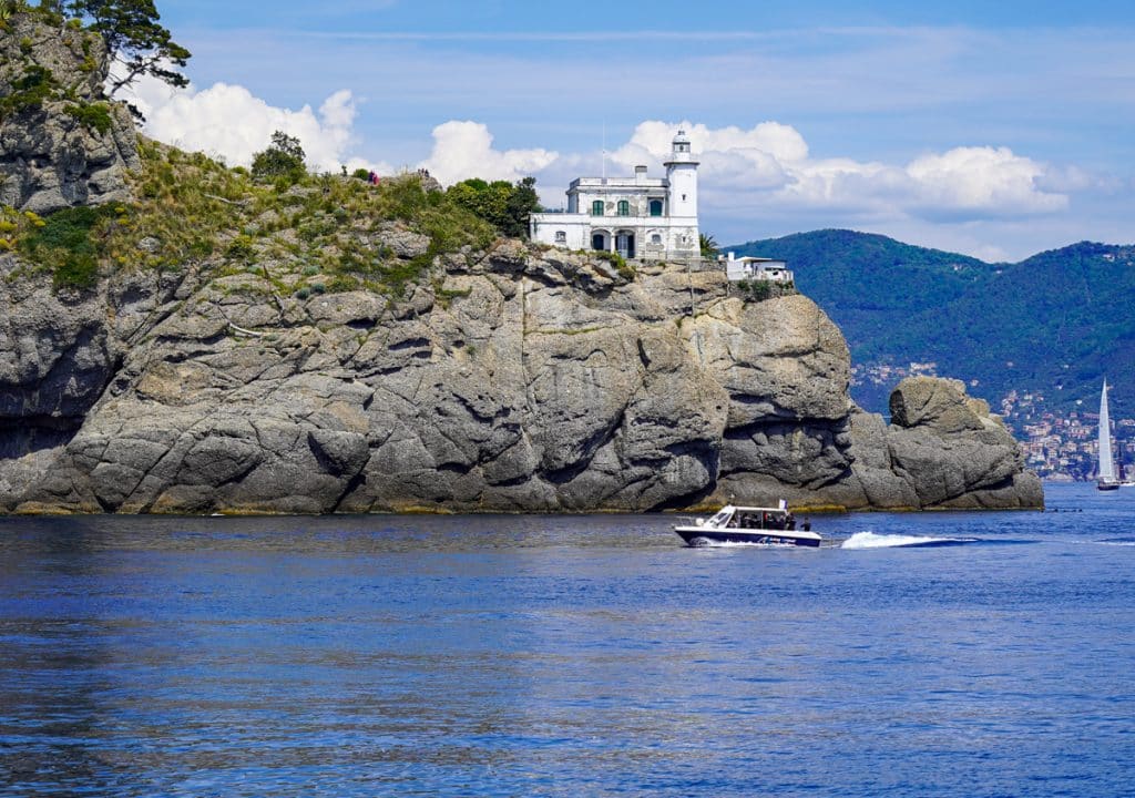 white lighthouse on a cliff - Portofino Lighthouse in Italy