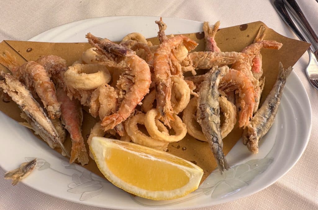 a dish of mixed seafood on a dish in Portofino Italy