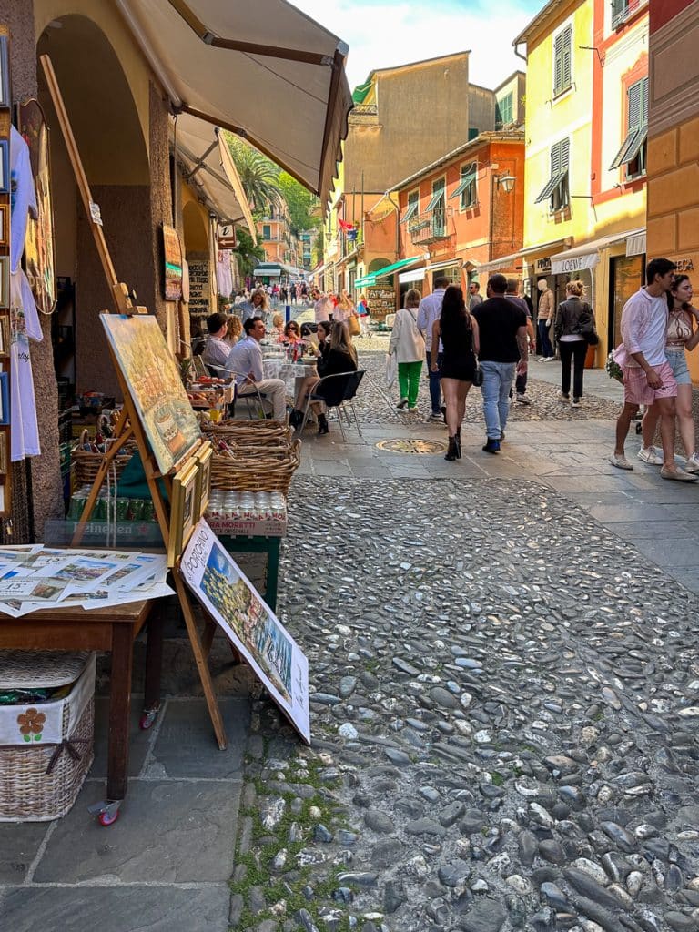 street in Portofino with goods for sale and people walking