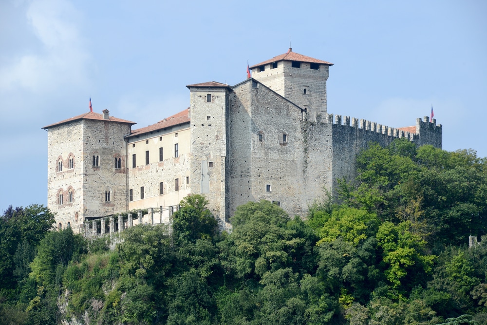 medieval fortress on a hilltop surrounded by green trees