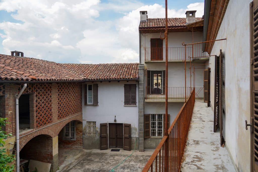 A white house with brown shutters and a balcony in Italy