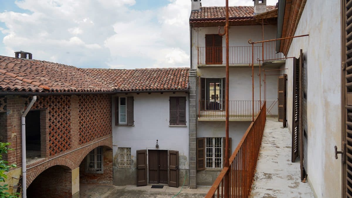 A white house with brown shutters and a balcony in Italy