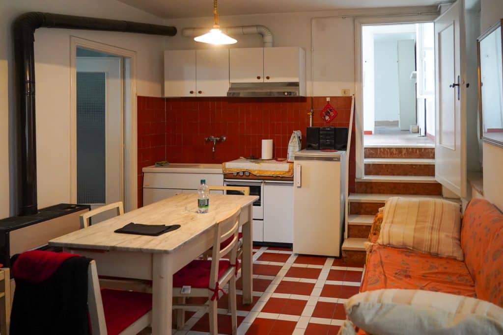 red kitchen with white cabinets and table in an old Italy house