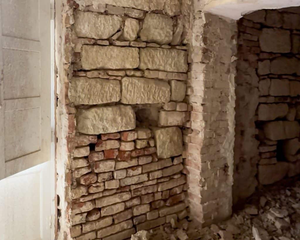 Italian house renovation closeup of a wall with a mix of different bricks after the paster was removed