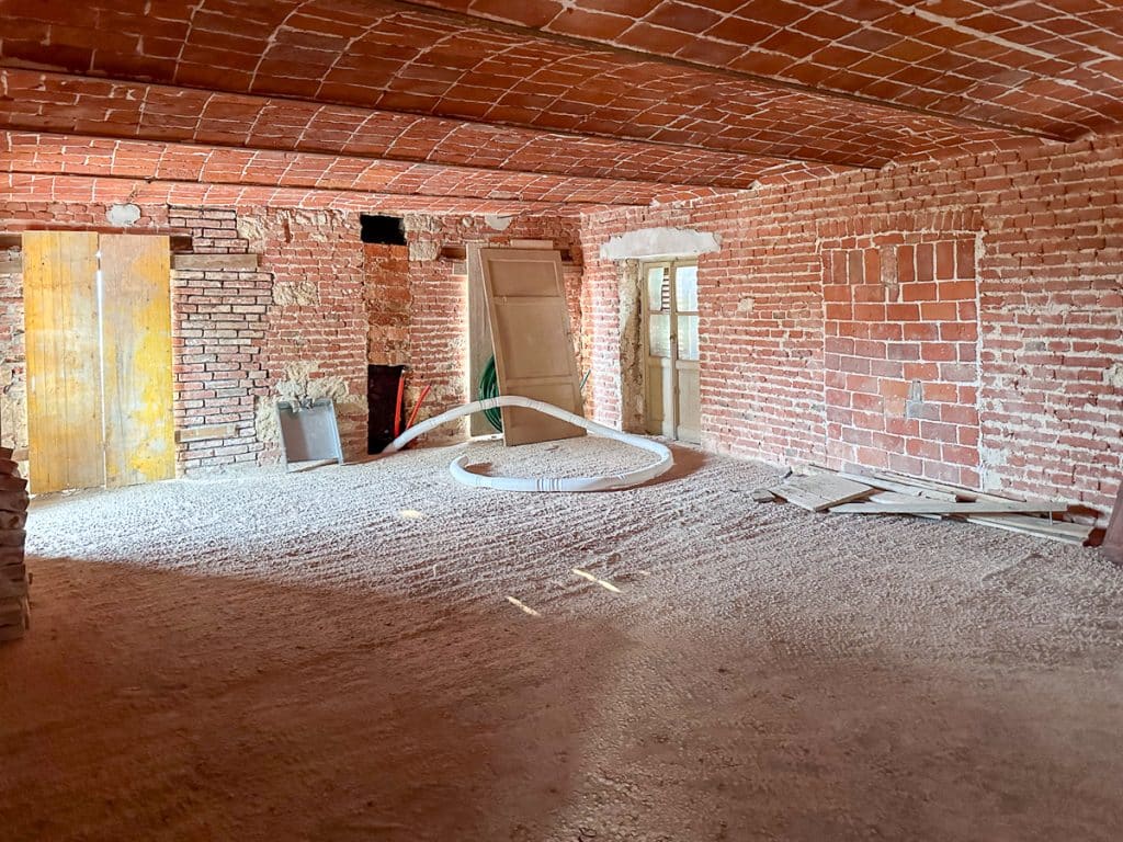 a room with brick walls and ceilings part of the way through a renovation
