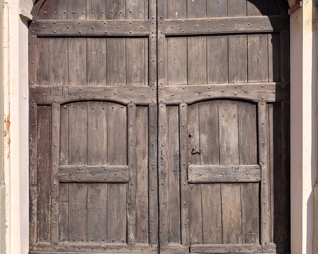 big wooden gate on a house. The gate is worn and splintering